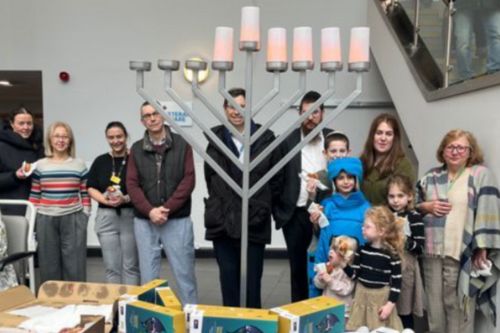 Celebrating Chanukah a large menorah with people gathered around it